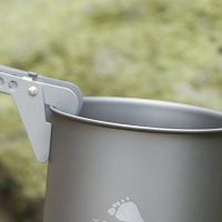 using a pot lifter to move a pot while camping