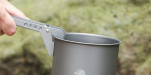 using a pot lifter to move a pot while camping